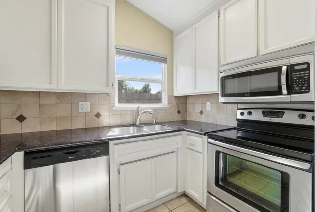 a kitchen with cabinets stainless steel appliances and a sink