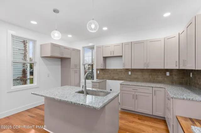 a kitchen with stainless steel appliances granite countertop a sink a stove and a refrigerator