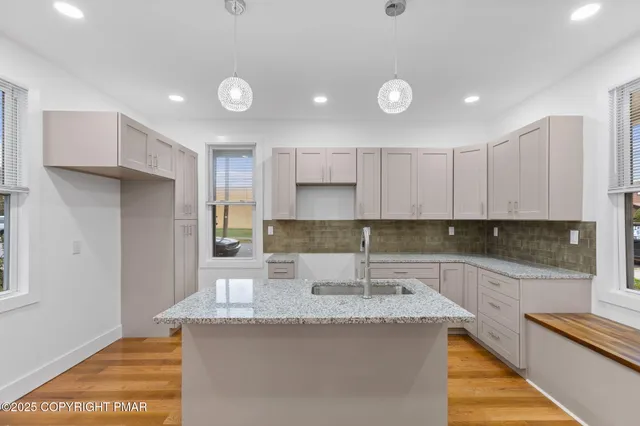 a kitchen with kitchen island granite countertop a sink and refrigerator