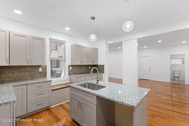a kitchen with granite countertop a sink and cabinets