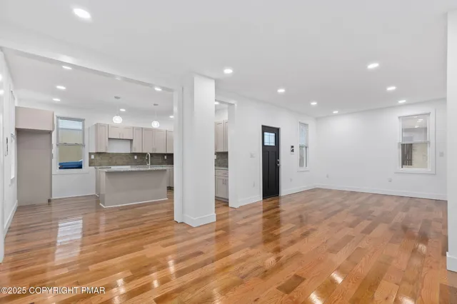 a view of kitchen with kitchen island white cabinets and refrigerator