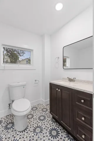 a bathroom with a toilet a sink and mirror