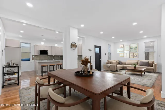 a room with stainless steel appliances kitchen island granite countertop a dining table chairs and view living room