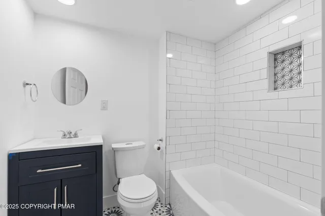 a bathroom with a bathtub shower sink vanity and toilet