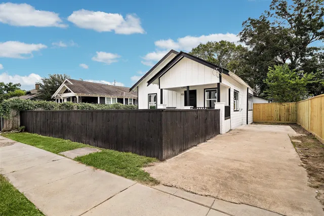 a view of backyard with small cabin and wooden fence