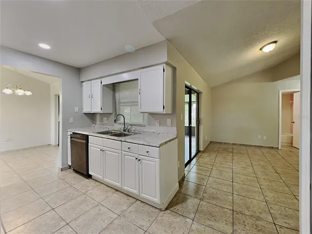 a kitchen with granite countertop a sink and cabinets