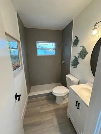 a bathroom with a sink a toilet and shower