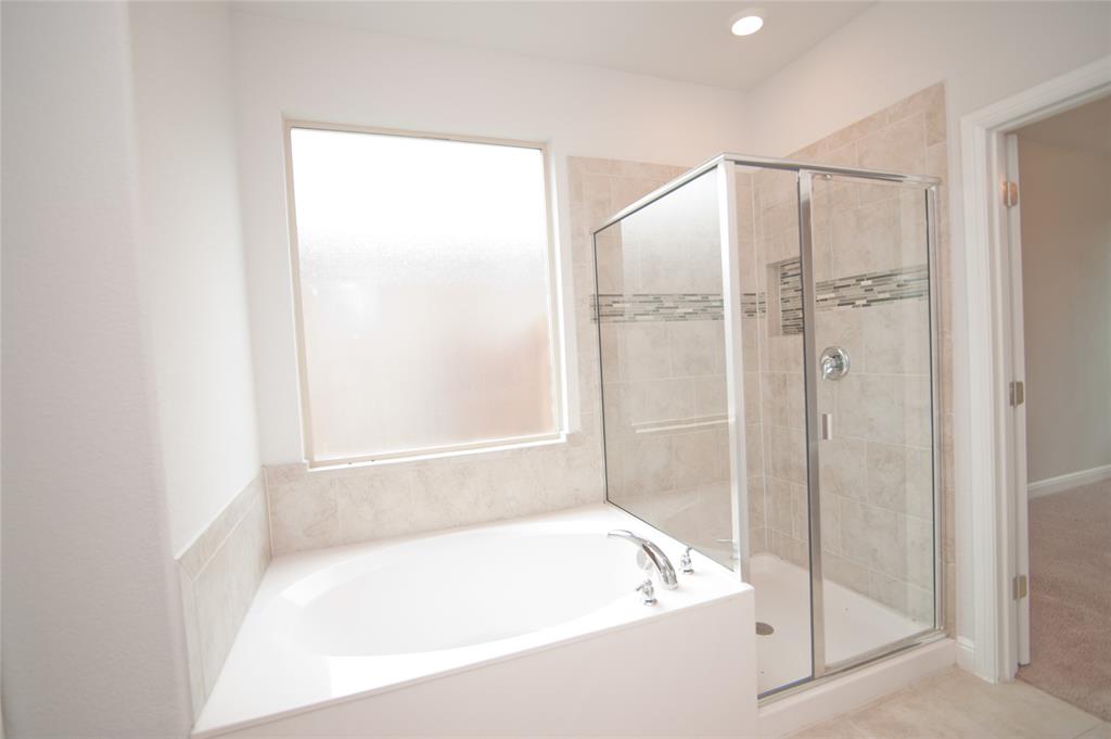 1021 Gillespie Drive Fort Worth, TX 76247 - Photo 20 of 38 a bathroom with a bathtub and a shower