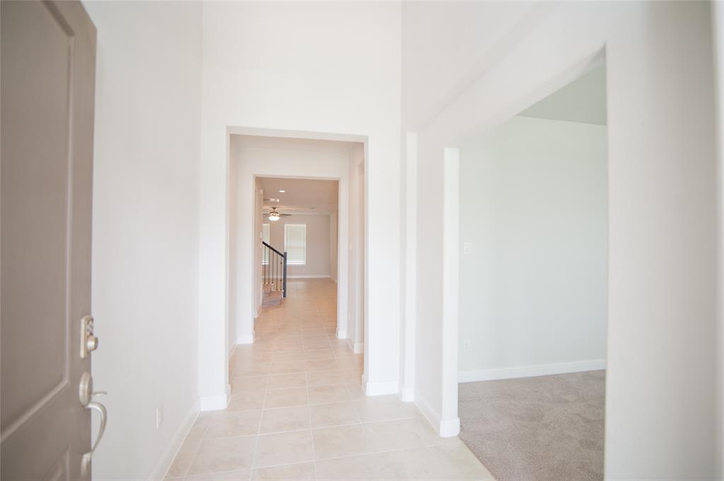 1021 Gillespie Drive Fort Worth, TX 76247 - Photo 2 of 38 a view of a hallway with wooden floor and a bathroom