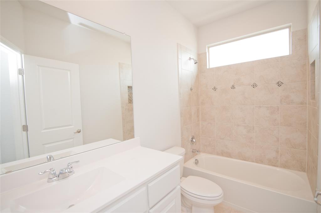 1021 Gillespie Drive Fort Worth, TX 76247 - Photo 30 of 38 a bathroom with a bathtub shower sink vanity and toilet