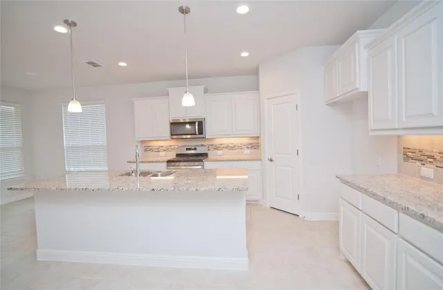 a kitchen with granite countertop a stove and a sink