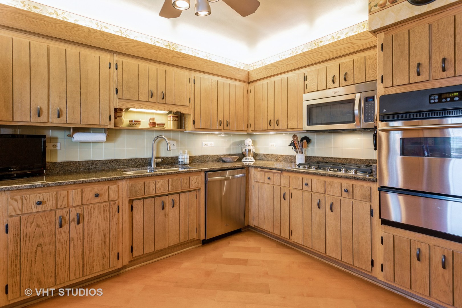 4545 North Long Avenue, Unit 3D Chicago, IL 60630 - Photo 6 of 19 a kitchen with granite countertop a stove top oven a sink dishwasher and cabinets with wooden floor