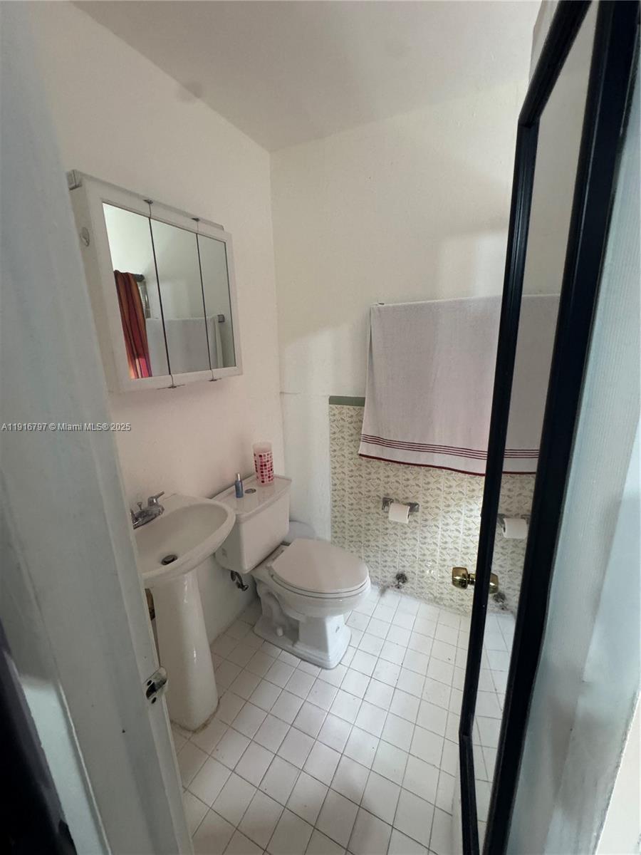 11012 Southwest 4th Street Sweetwater, FL 33174 - Photo 14 of 19 a bathroom with a toilet and a mirror