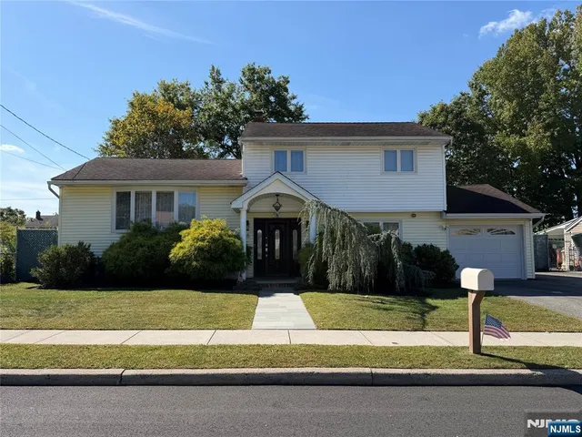 a front view of a house with a yard and a garage