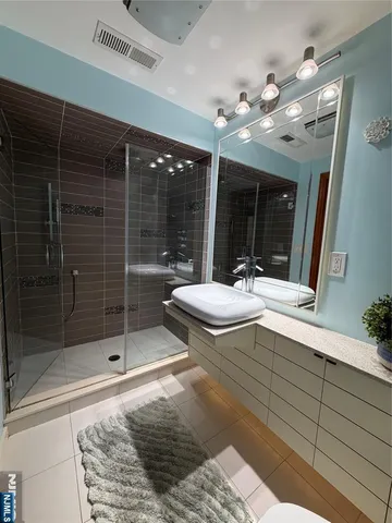 a bathroom with a sink a large mirror and shower