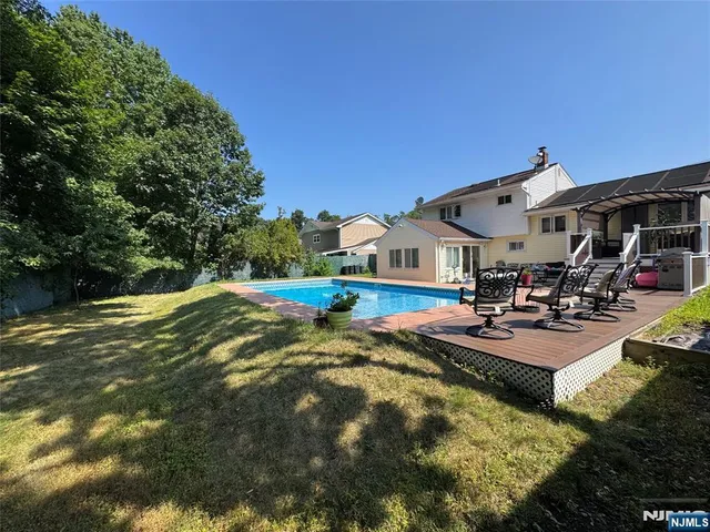 a view of a house with swimming pool and sitting area