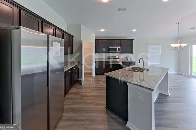 a kitchen with kitchen island a counter top space cabinets and stainless steel appliances