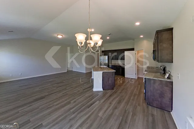 a dining room with wooden floor a chandelier a wooden table and chairs