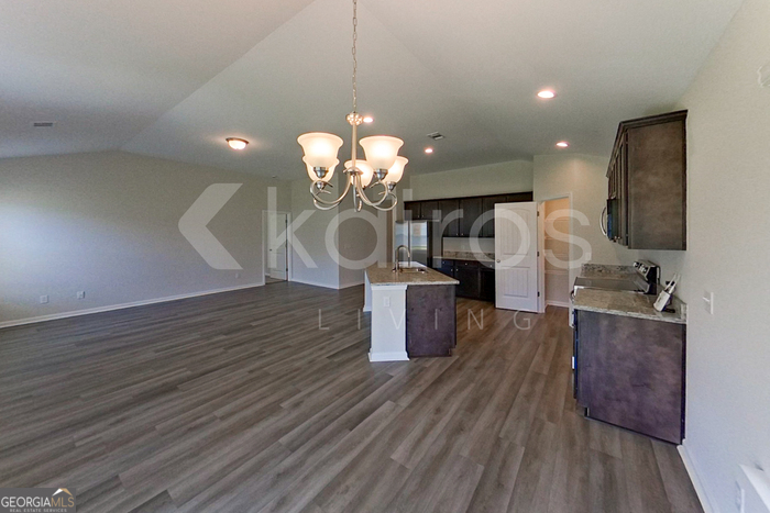 105 Bluff Road Springfield, GA 31329 - Photo 7 of 21 a dining room with wooden floor a chandelier a wooden table and chairs