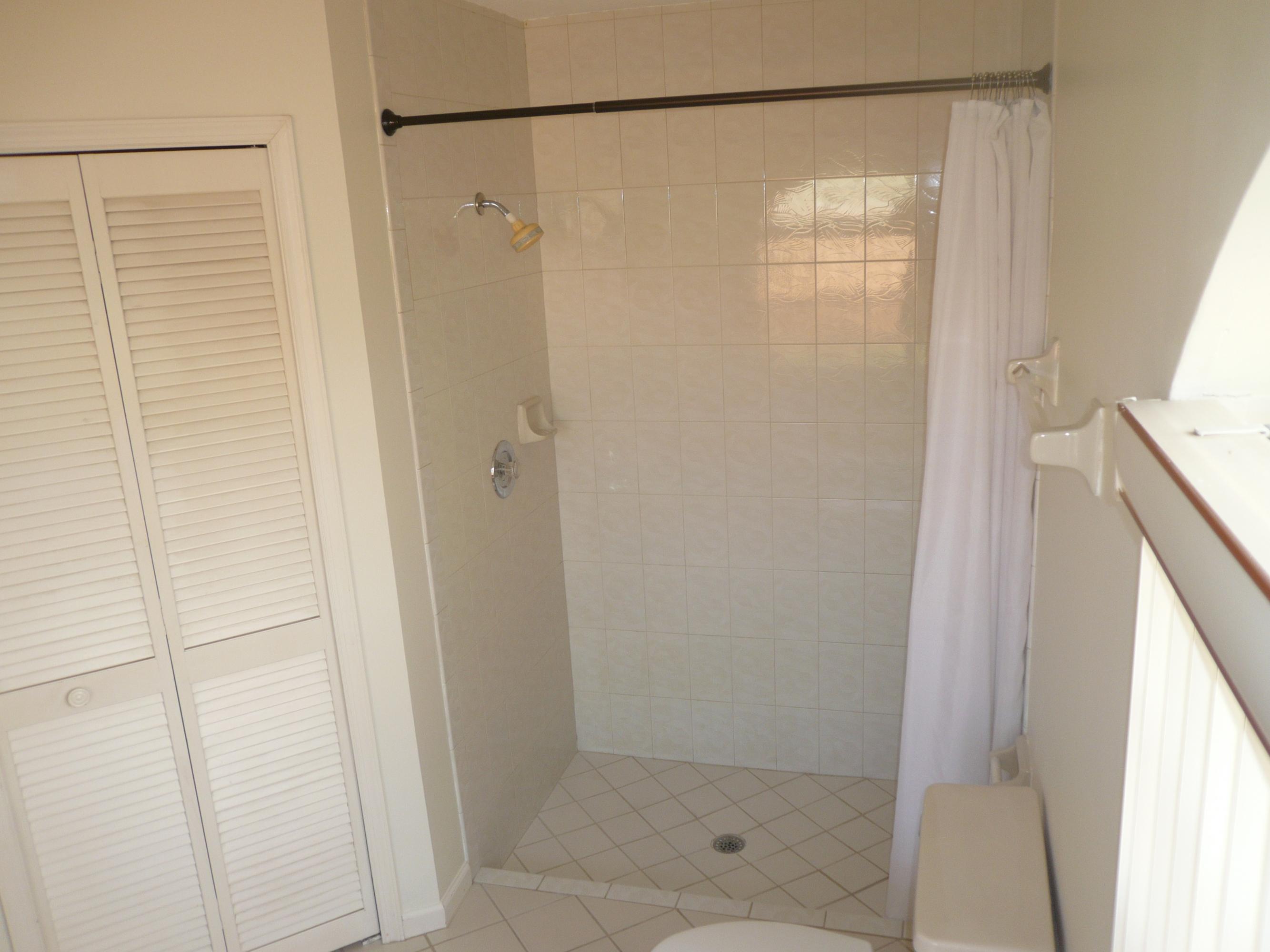 6287 Garrett Street Jupiter, FL 33458 - Photo 12 of 17 a bathroom with a glass shower door