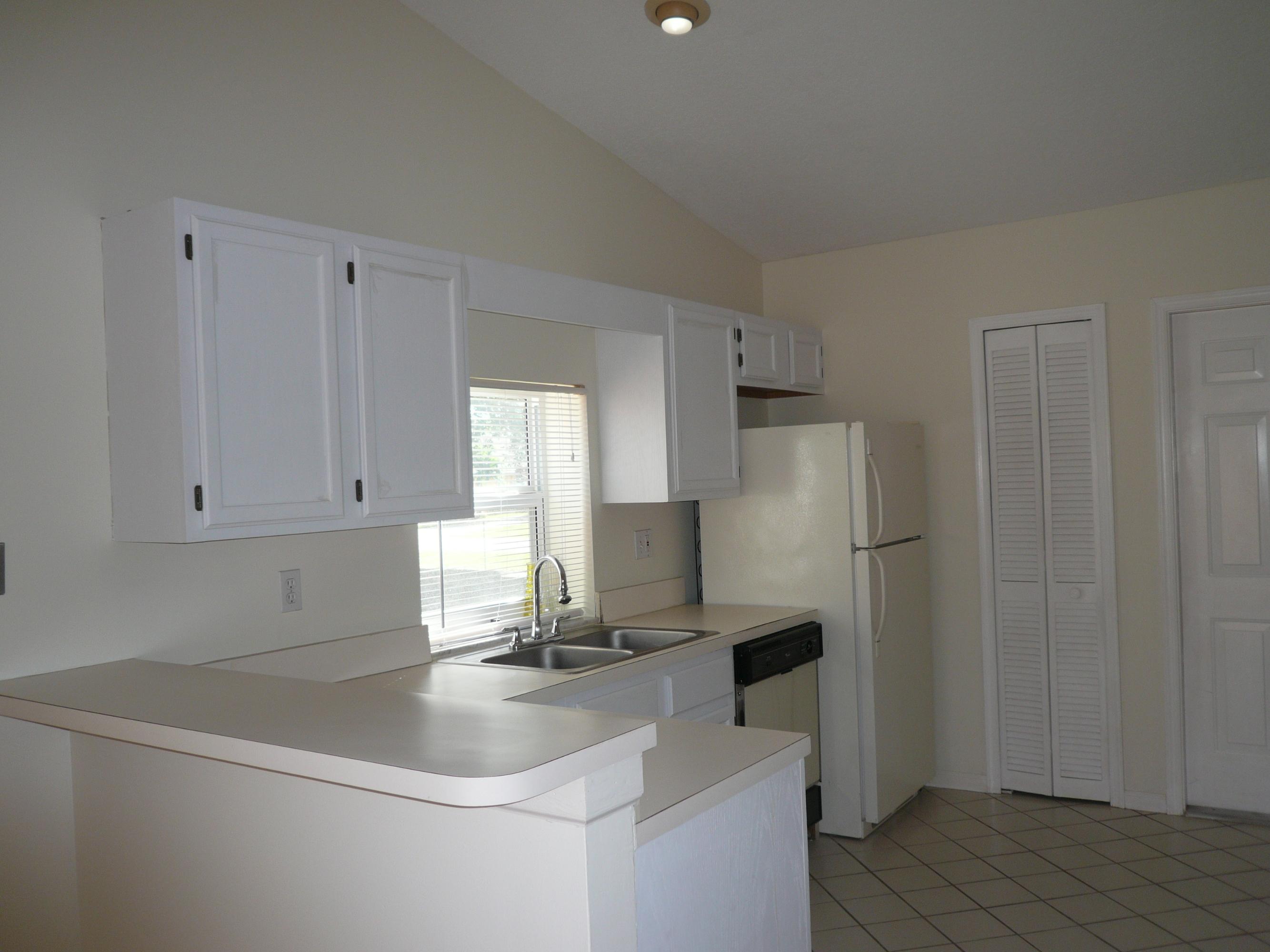 6287 Garrett Street Jupiter, FL 33458 - Photo 6 of 17 a kitchen with a sink a refrigerator and cabinets