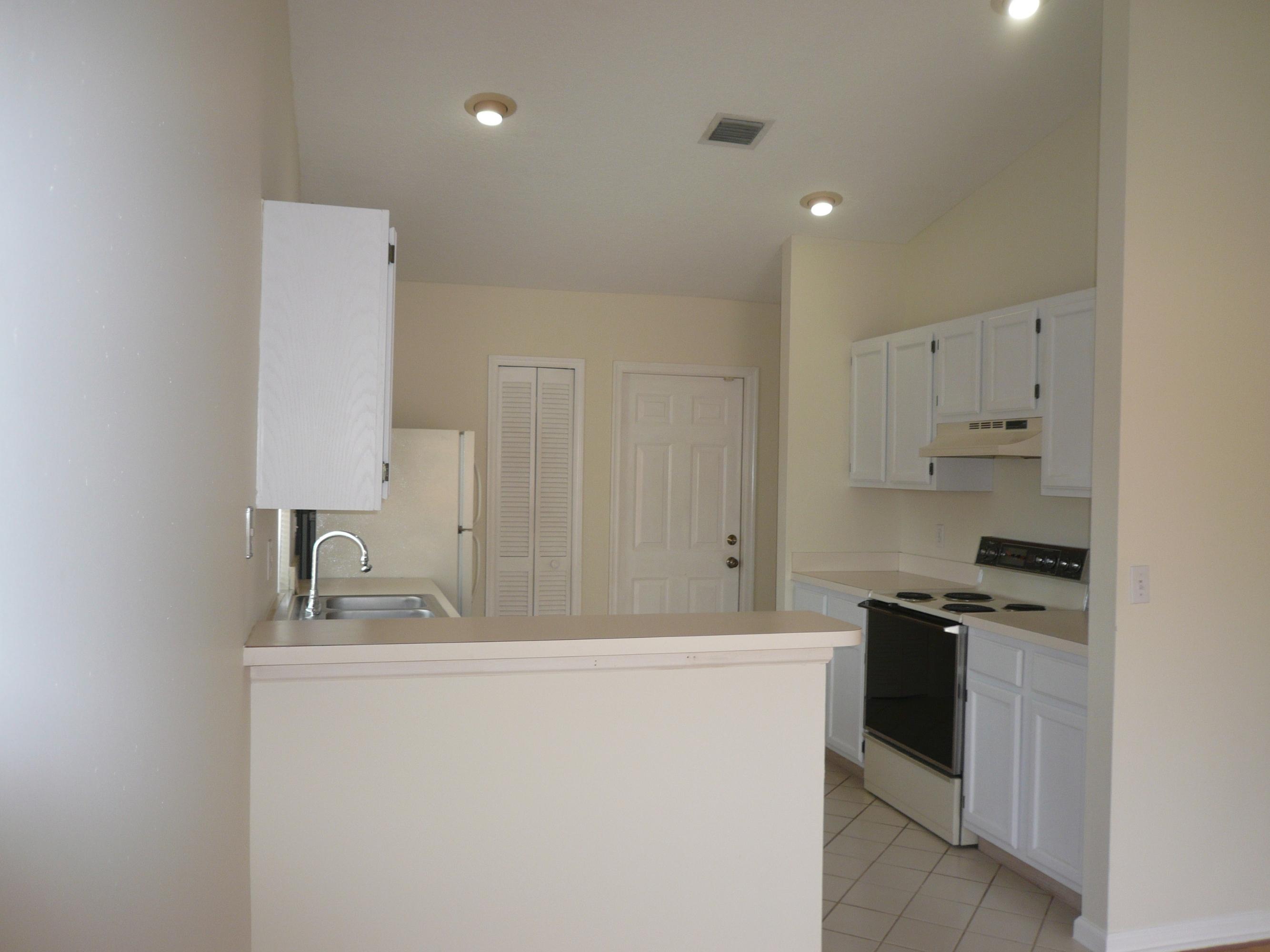 6287 Garrett Street Jupiter, FL 33458 - Photo 8 of 17 a kitchen with kitchen island white cabinets and stainless steel appliances