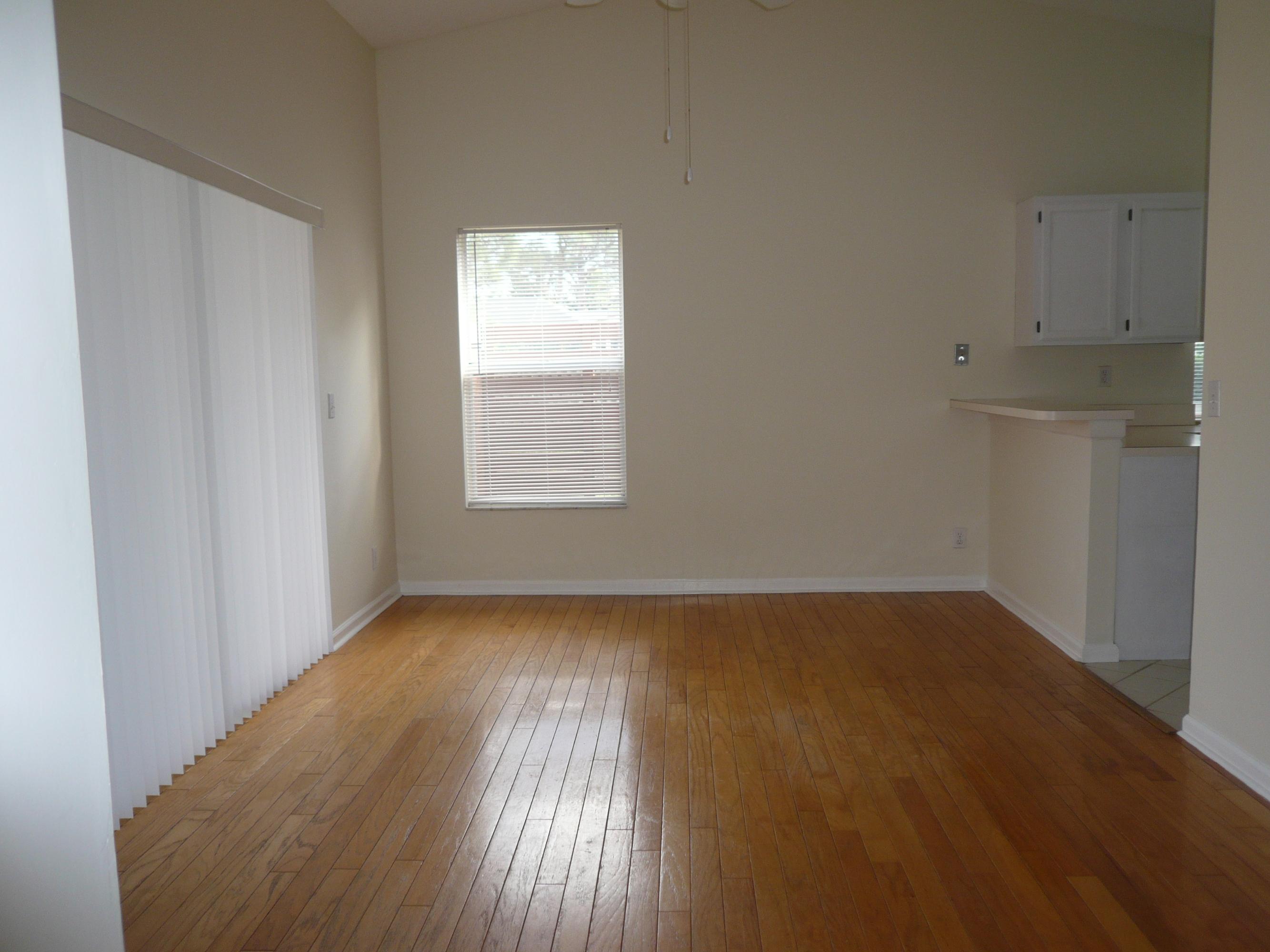 6287 Garrett Street Jupiter, FL 33458 - Photo 9 of 17 an empty room with wooden floor and windows