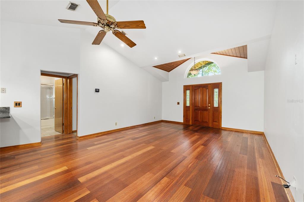 12861 Southwest 45th Lane Road Ocala, FL 34481 - Photo 13 of 73 an empty room with wooden floor ceiling fan and windows