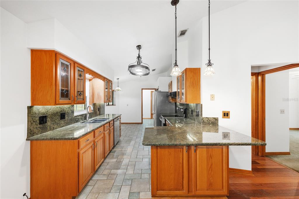12861 Southwest 45th Lane Road Ocala, FL 34481 - Photo 18 of 73 a kitchen with stainless steel appliances granite countertop a sink counter space and living room view
