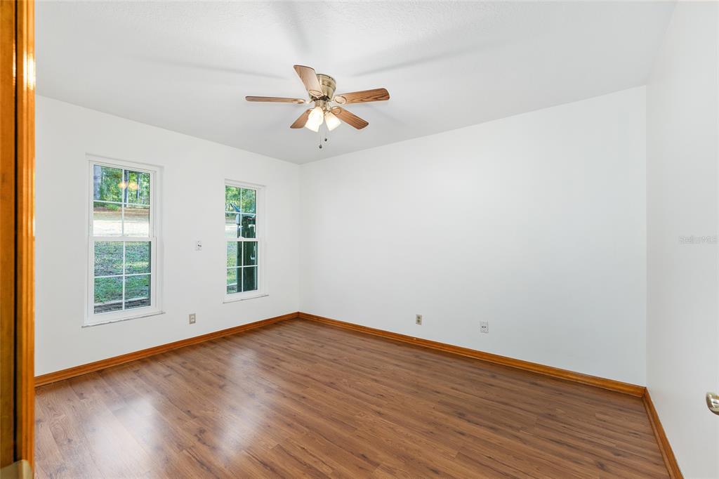 12861 Southwest 45th Lane Road Ocala, FL 34481 - Photo 33 of 73 an empty room with wooden floor fan and windows