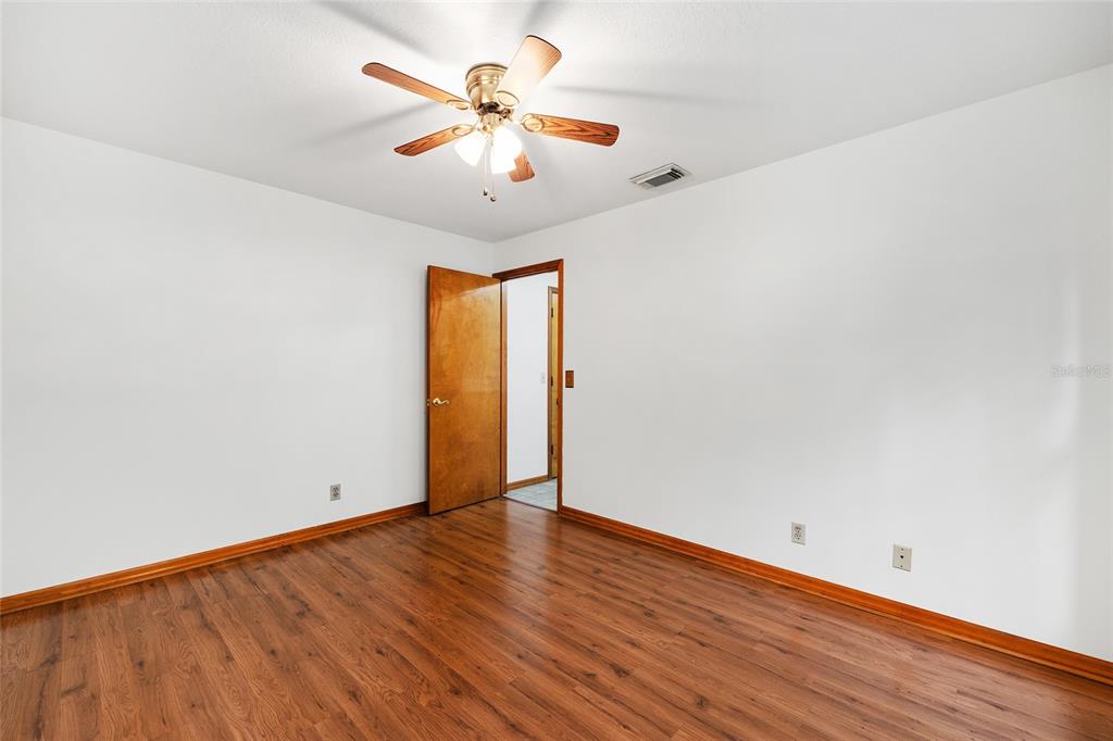 12861 Southwest 45th Lane Road Ocala, FL 34481 - Photo 34 of 73 an empty room with wooden floor and chandelier fan