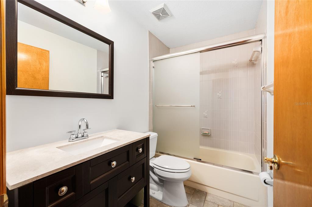 12861 Southwest 45th Lane Road Ocala, FL 34481 - Photo 37 of 73 a bathroom with a sink a mirror a toilet and shower