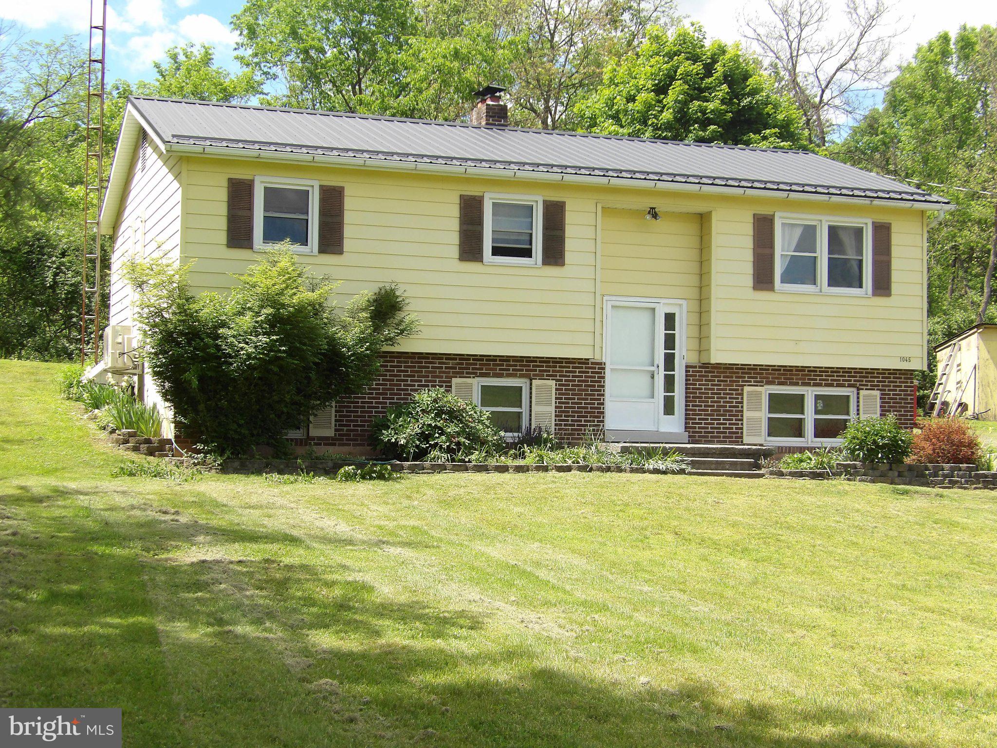 1045 Lockport Road Lewistown, PA 17044 - Photo 41 of 51 Charming yellow home with lush greenery.