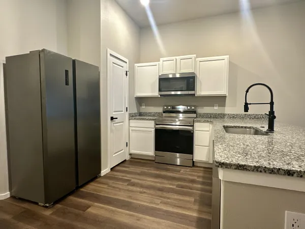 a kitchen with stainless steel appliances granite countertop a stove a sink and a refrigerator