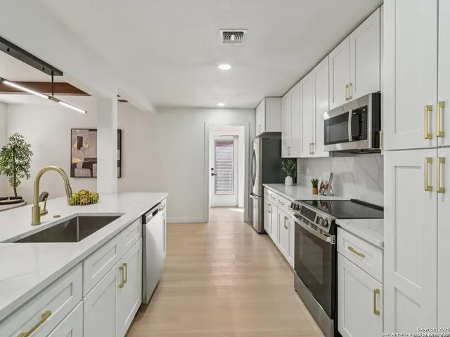 a kitchen with stainless steel appliances a stove a sink and a microwave