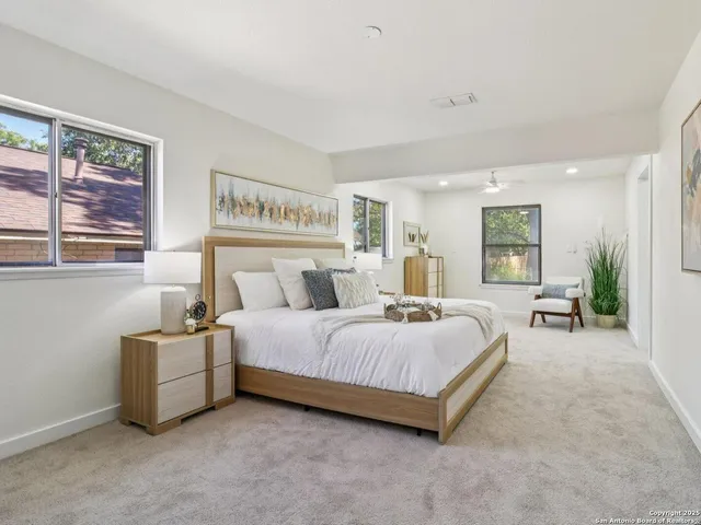 a spacious bedroom with a bed and a cabinets