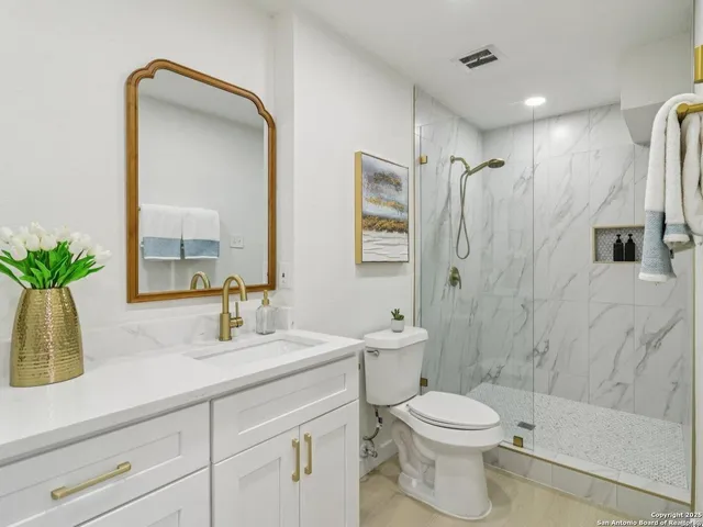 a bathroom with cabinets two sinks a vanity and a shower