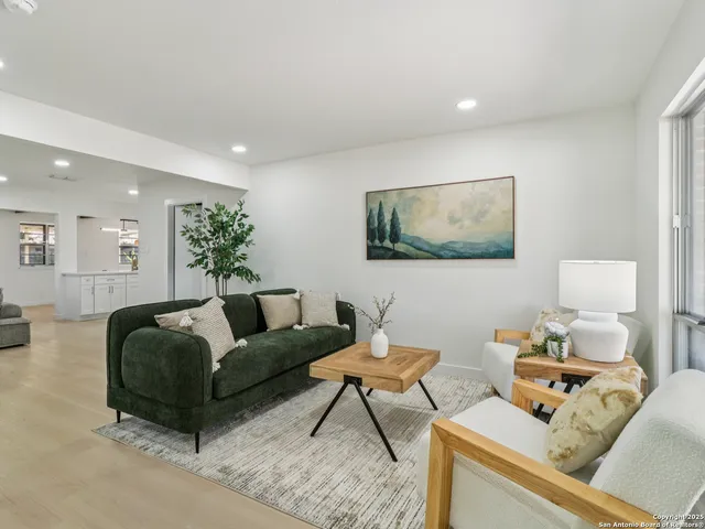 a living room with furniture and view of kitchen