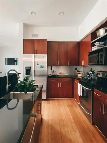 a kitchen with granite countertop a refrigerator and a stove top oven