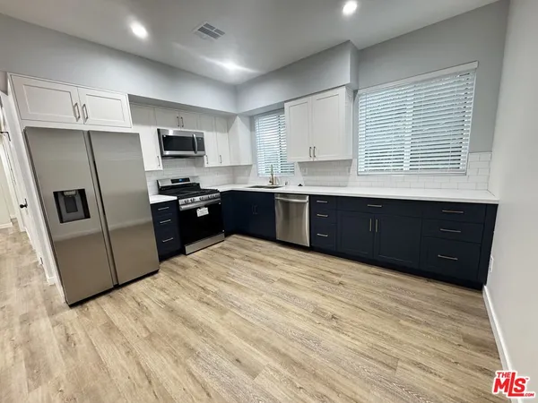 a kitchen with stainless steel appliances granite countertop a refrigerator and a sink