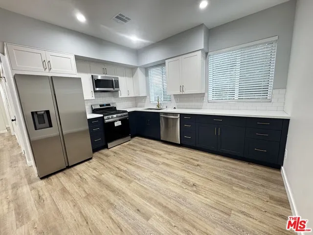 a kitchen with stainless steel appliances granite countertop a refrigerator and a sink