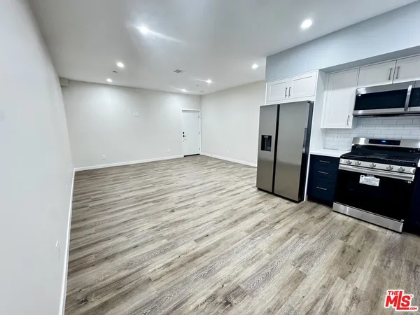 a view of kitchen with refrigerator microwave and stove