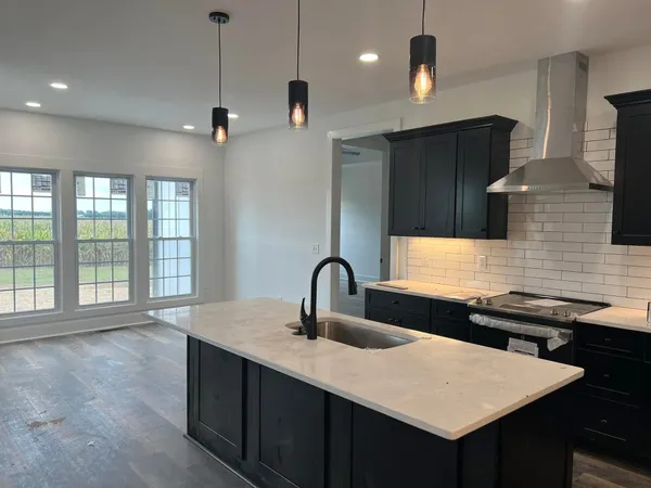 a kitchen with granite countertop a sink stainless steel appliances and cabinets