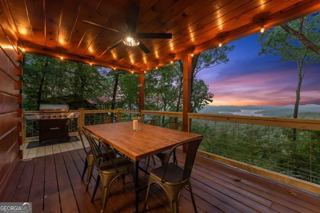 a view of a patio with table and chairs with wooden floor and fence