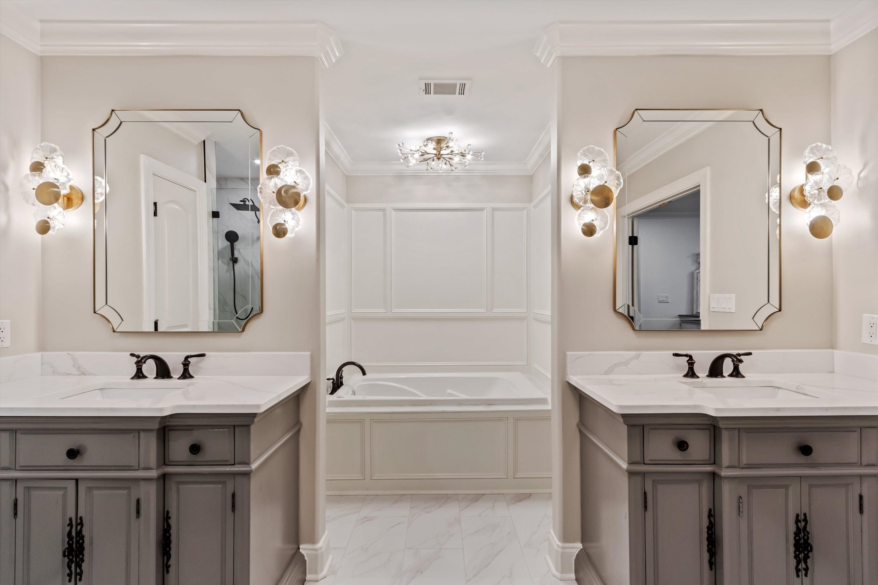 5302 South Angela Road Memphis, TN 38120 - Photo 21 of 40 Dual vanity bathroom featuring gray cabinetry with black hardware, white countertops, and decorative sconces
