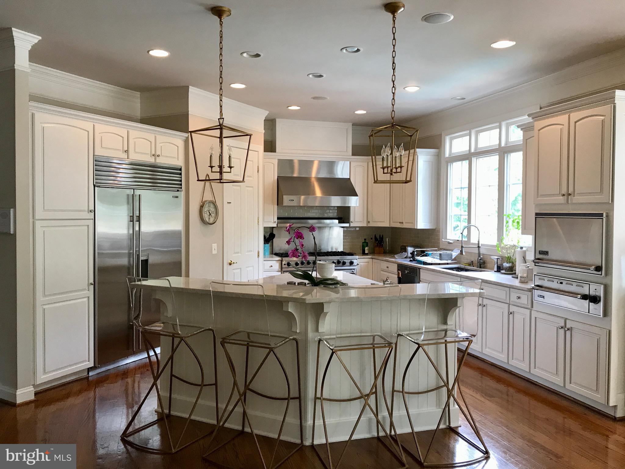 43295 Fieldsview Court Leesburg, VA 20176 - Photo 3 of 30 a kitchen with stainless steel appliances granite countertop a sink a stove a refrigerator cabinets and dining table