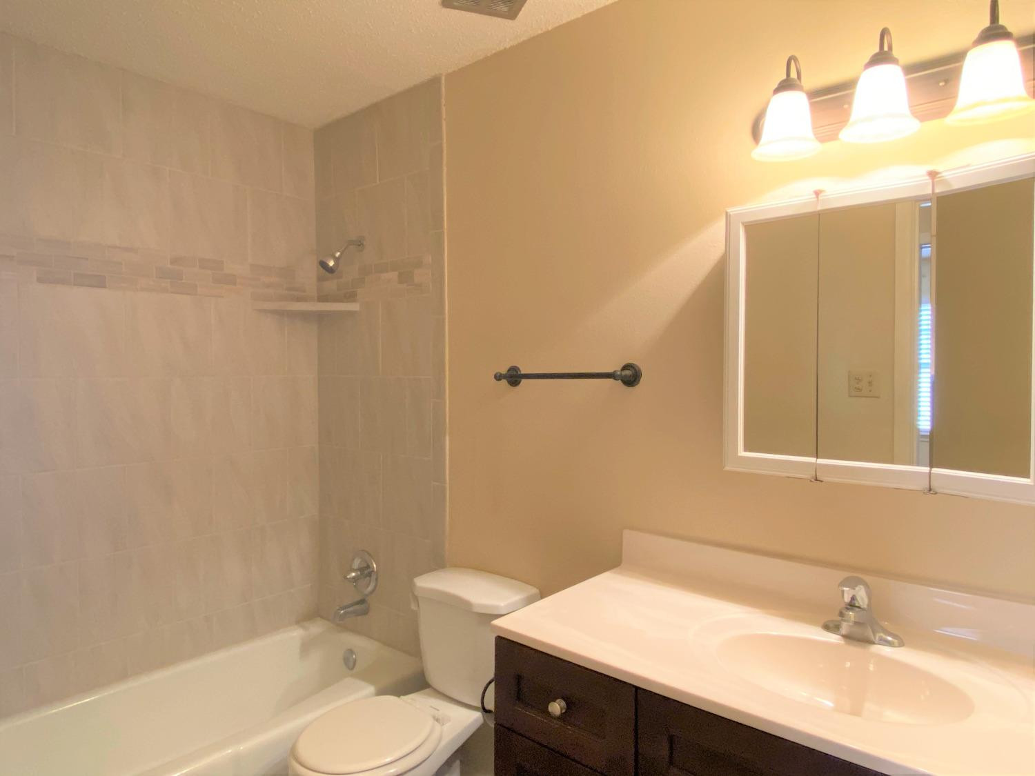 4210 18th Street, Unit A Lubbock, TX 79416 - Photo 8 of 12 a bathroom with a sink toilet and shower