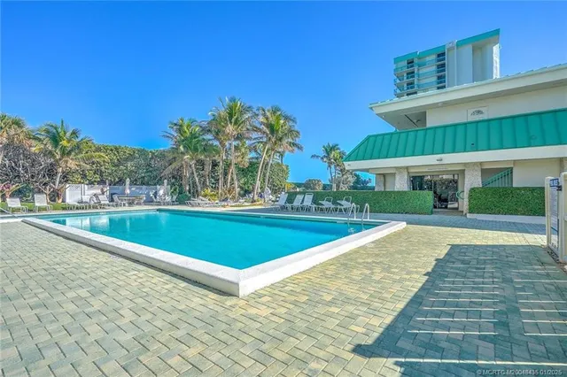 a view of swimming pool with outdoor seating and yard in the back