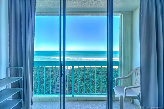 a view of a glass door with a chair from a room