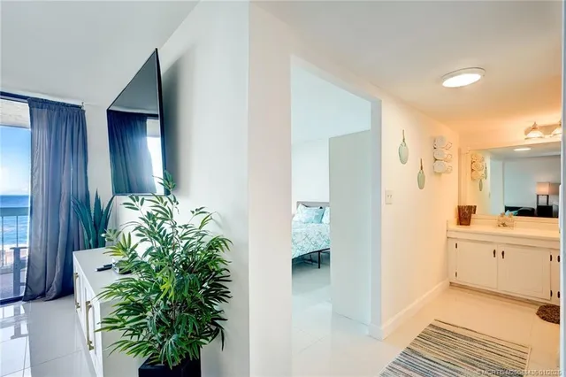 a view of a hallway with wooden floor and a living room